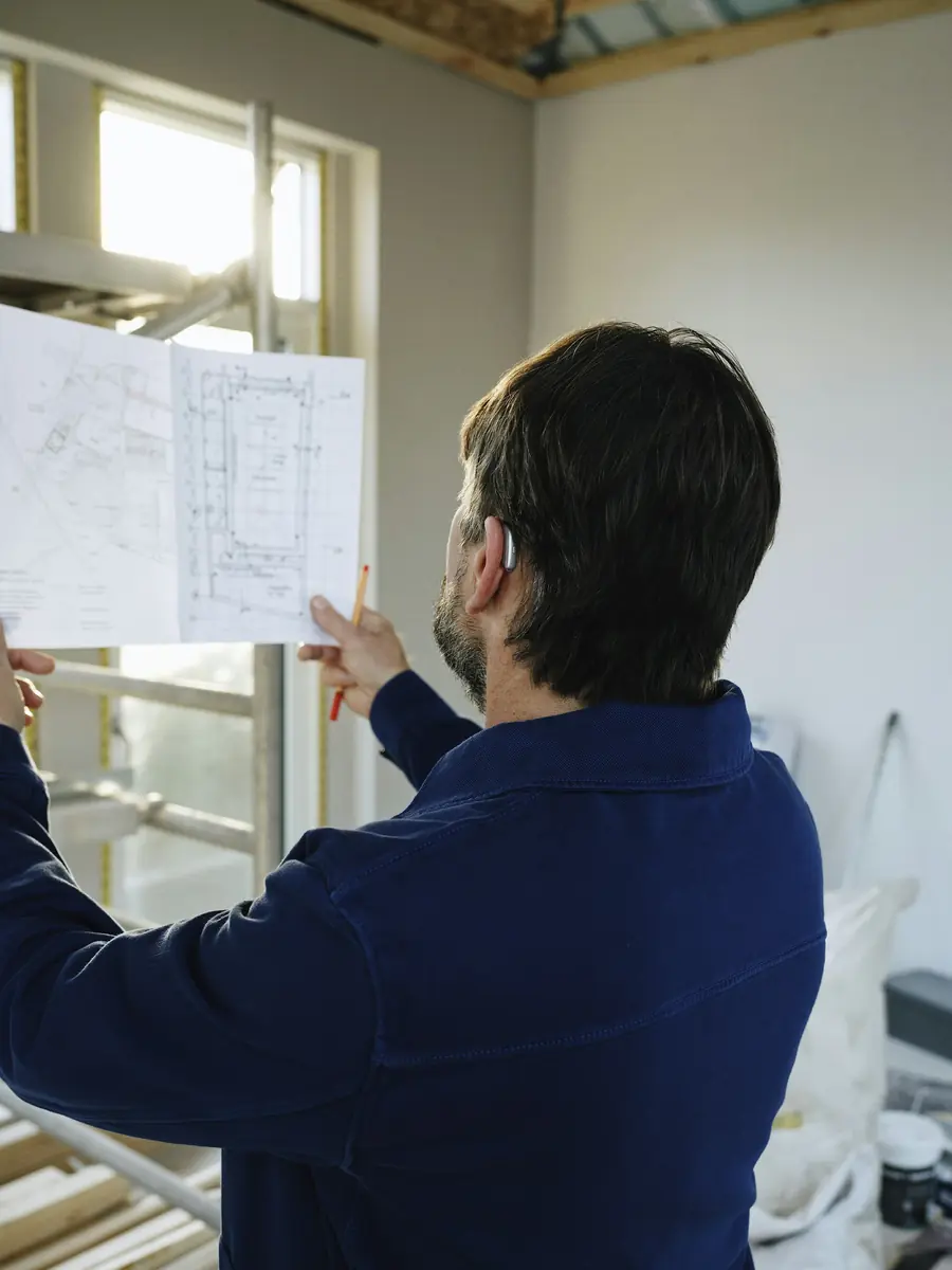 Contractor reviewing plans in a room under renovation